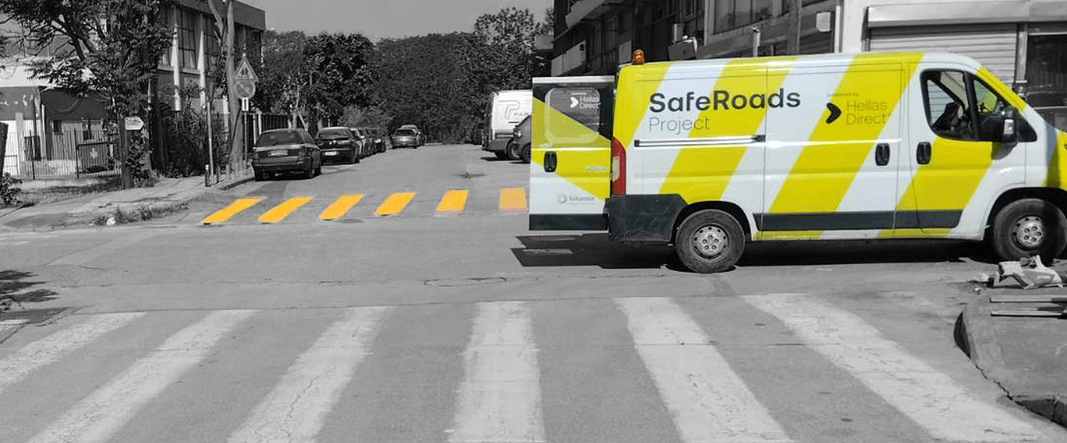 Διασταύρωση, παρκαρισμένο το van του Safe Roads project, στο φόντο πολύχρωμη διάβαση