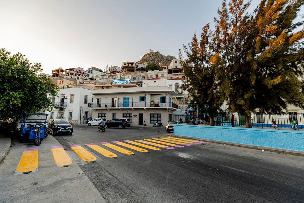 Μέρα στην Κάλυμνο, διάβαση με κίτρινα μολύβια έξω από σχολείο., στο φόντο σπίτια του νησιού