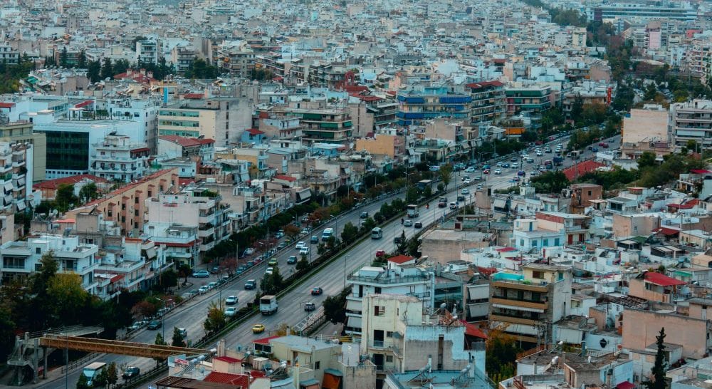 Τμήμα της Αθήνας απο ψηλά, φαίνοται πολλά σπίτια και μεγάλη λεωφόρος με διπλή κυκλοφορία