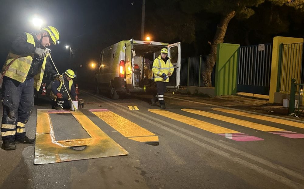 το συνεργείο του Safe Roads projectβάφει διάβαση μπροστά από σχολείο, στο βάθος το βαν