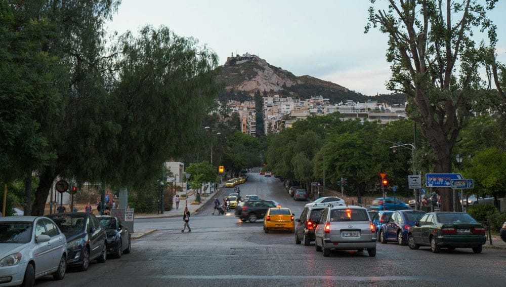 δρόμος στην Αθήνα με αυτοκίνητα εν κινήσει, στο βάθος ο Λυκαβηττός